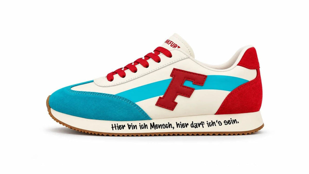 F/LOW Frankfurt Edition: cremefarbener Sneaker mit rotem F-Patch und blauer Main-Linie vor der Frankfurter Skyline im Abendlicht.