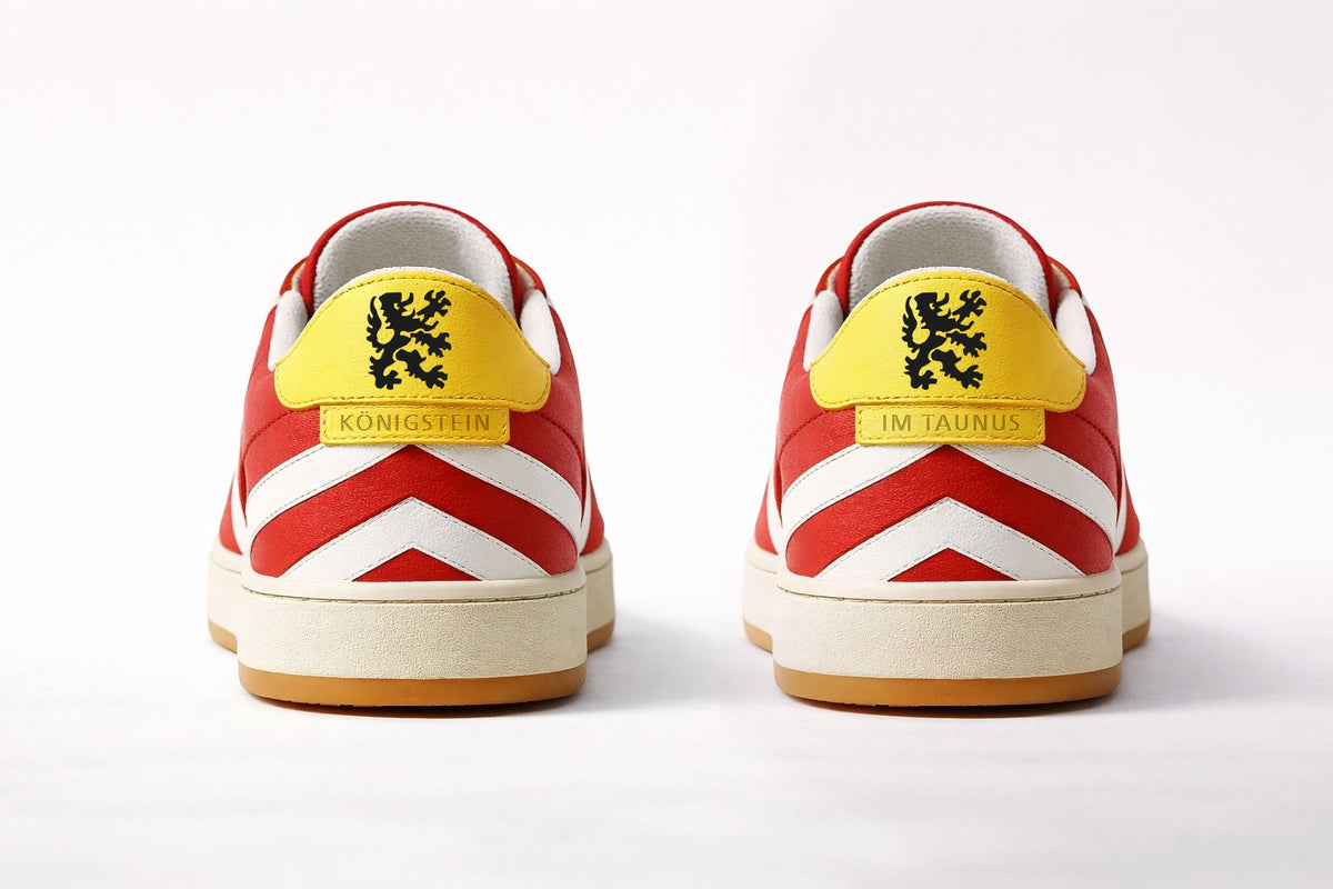 Rückansicht beider Sneaker: gelber Fersenbesatz mit schwarzem Königsteiner Löwen.