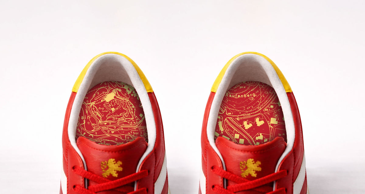Blick in beide Sneaker: Innensohlen mit Stadtkarte in Gold auf Rot.