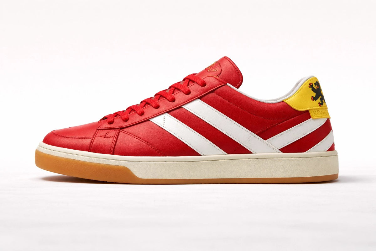 K///STRIPE Königstein Edition: roter Sneaker mit weißen Streifen und gelbem Fersenbesatz.